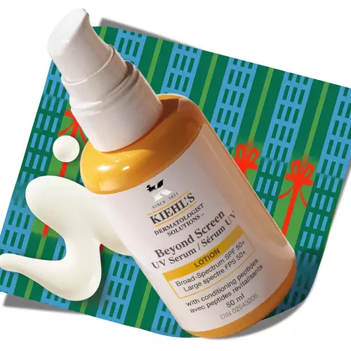 Kiehl's Better Screen UV Serum bottle with a dollop of serum, resting on a patterned holiday background.