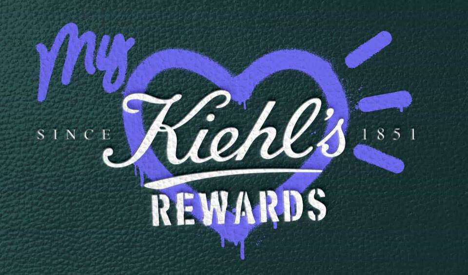 "My Kiehl’s Rewards" logo with a purple heart graphic on a green textured background.