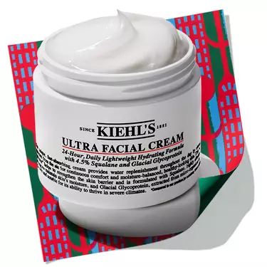 Open jar of Kiehl's Ultra Facial Cream set against a holiday-themed patterned background.